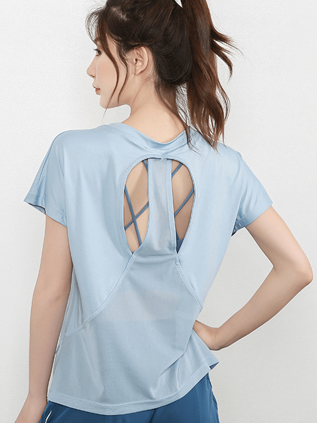 Woman wearing short sleeves mesh yoga t-shirt with stylish back design, perfect for active lifestyle and yoga sessions, in light blue.